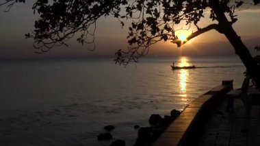 gün batımı arka plan üzerinde denizde tekne yelken. Bir adam teknenin pruvası, teknenin arkasında başka bir kişi duruyor