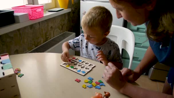 Autistic Child Collects Colored Jigsaw Puzzles Forms Help Teacher — Stock Video