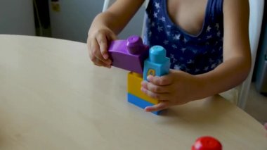 otistik çocuk bir görevi yerine getirir - yakından bir asistan örneğini takip eden bir yapıcı toplar