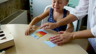 otistik bir çocuk gözlerinde yaşlar ile bir bulmaca nın bir resim bağlayan bir asistan görevi gerçekleştirir