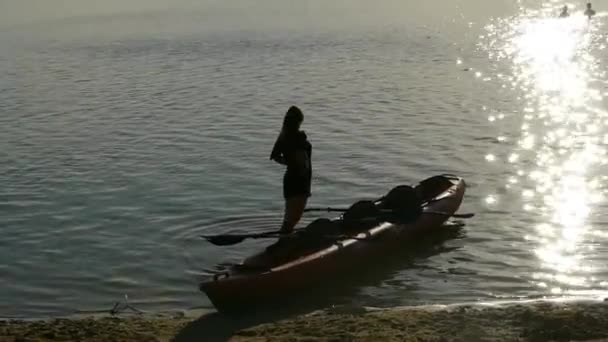 Silhouet Van Een Vrouw Buurt Van Een Kajak Het Meer — Stockvideo