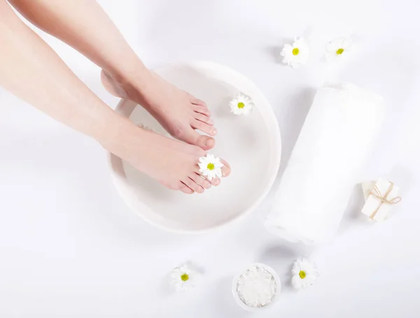 Vrouwelijke Voeten Met Spa Kom Handdoek Bloemen Witte Achtergrond — Stockfoto