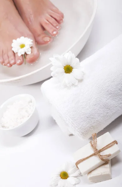 Vrouwelijke Voeten Met Spa Kom Handdoek Bloemen Witte Achtergrond — Stockfoto