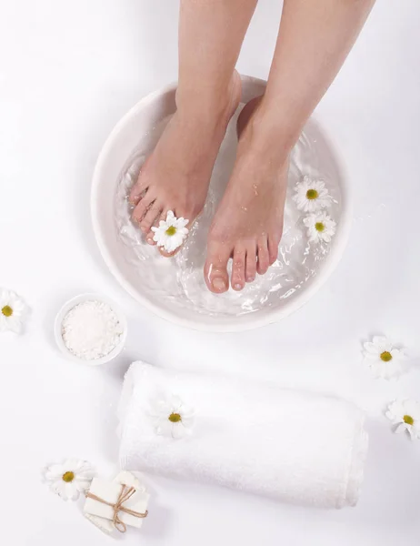 Vrouwelijke Voeten Met Spa Kom Handdoek Bloemen Witte Achtergrond — Stockfoto