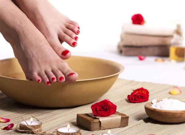 Frauenfüße Mit Wassertropfen Wellnessschale Handtüchern Blumen Kerzen Meersalz Und Flasche — Stockfoto