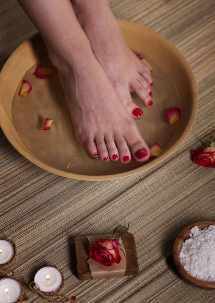 Kvinnliga Fötter Med Spa Skål Blommor Ljus Havssalt Och Tvål — Stockfoto