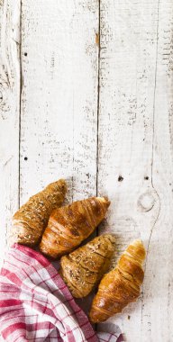 Kruvasan kopya alanı ile beyaz ahşap zemin üzerinde