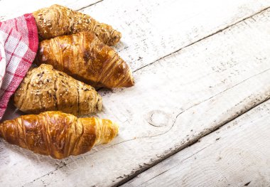 Kruvasan kopya alanı ile beyaz ahşap zemin üzerinde