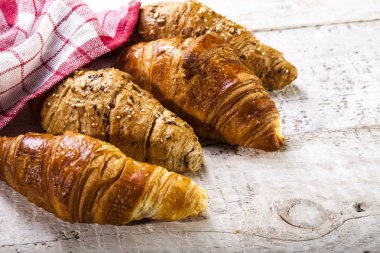 Kruvasan kopya alanı ile beyaz ahşap zemin üzerinde