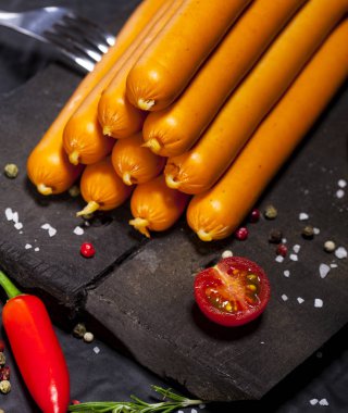 Wiener sosis siyah arka plan üzerine baharat ile