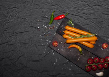 Siyah arka plan üzerine baharat ile Wiener sosis. Kopya alanı ile üstten görünüm.