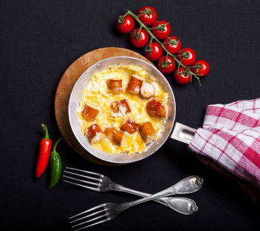 Sahanda yumurta ve sosis siyah arka plan üzerine bir tavada kahvaltı.