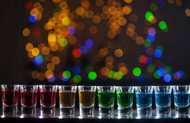 Küçük gözlük içine alkollü içki açık bar. Bardaki renkli kokteyller. Renkli çekim kulüpte. Alkollü içki farklı renklerde. Gece hayatı sahne. Bardaki çekim tablo.