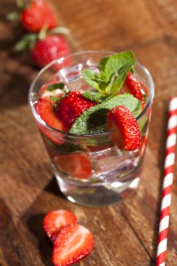 Çilek, nane ve buz cam ahşap zemin üzerine yaz soğuk içecek. Taze berry meyve ile kokteyller closeup.