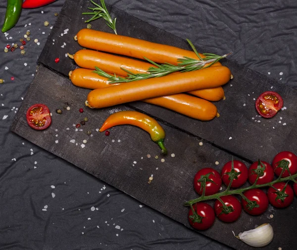 Siyah arka plan üzerine baharat ile Wiener sosis. Kopya alanı ile üstten görünüm.