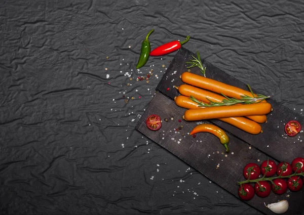 Siyah arka plan üzerine baharat ile Wiener sosis. Kopya alanı ile üstten görünüm.