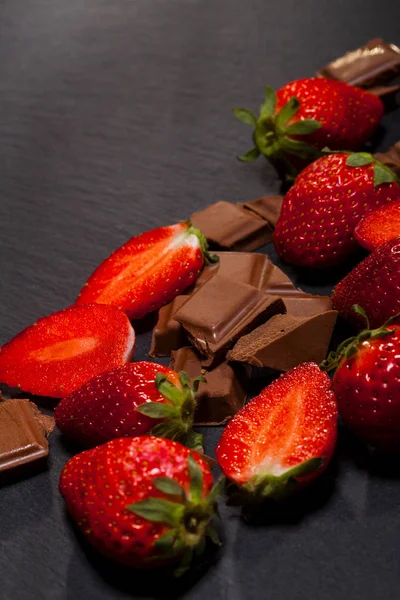 新鲜多汁草莓与叶子和巧克力片断在黑背景与拷贝空间 — 图库照片