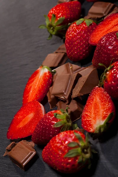 新鲜多汁草莓与叶子和巧克力片断在黑背景与拷贝空间 — 图库照片