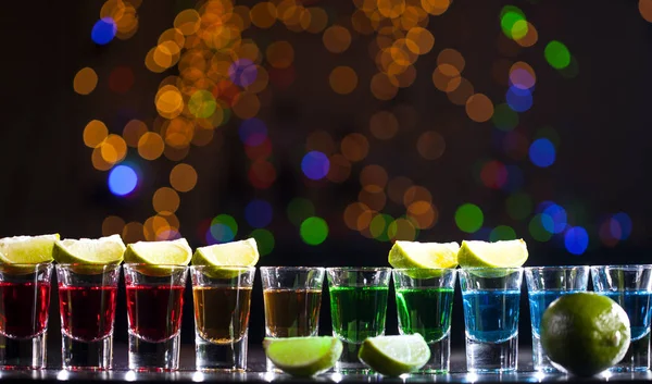 小さなグラスに酒のバー バーではカラフルなカクテル クラブでカラフルなショット 異なる色のアルコール飲料です ナイトライフ シーン バーでショット テーブル — ストック写真