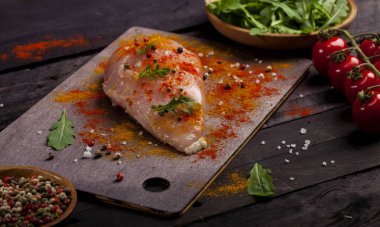 Kurulu ile baharat ve siyah bir zemin üzerine taze sebze ile çiğ tavuk fileto