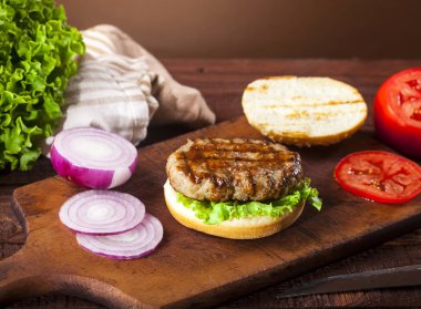 Taze lezzetli çizburger malzemeler ahşap arka plan üzerinde.