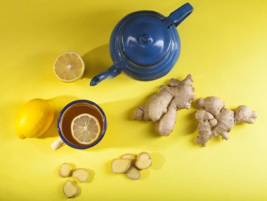 Sarı zemin üzerine limonlu zencefil çayı. Üstten görünüm.