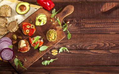 Bir kesme tahtası ve ahşap masa farklı mini sandviç topluluğu. En iyi görünüm ve kopya alanı.