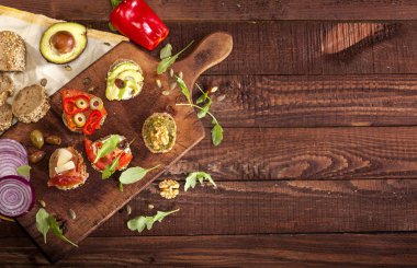 Bir kesme tahtası ve ahşap masa farklı mini sandviç topluluğu. En iyi görünüm ve kopya alanı.