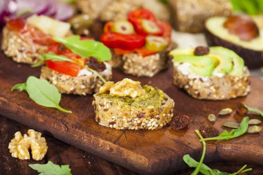 Bir kesme tahtası ve ahşap masa farklı mini sandviç closeup.