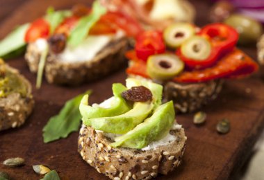 Bir kesme tahtası ve ahşap masa farklı mini sandviç closeup.