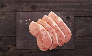 Çiğ et. Baharat kopya alanı ile siyah bir arka plan ile bir kesme tahtası üzerinde ham sığır eti biftek.