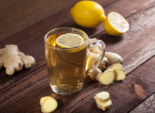 Ginger tea with lemon on a wooden background