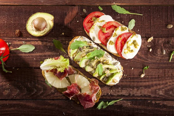 Bruschetta ahşap masa arka plan üzerinde üç farklı tür topluluğu.
