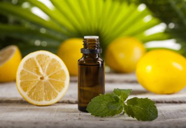 Yeşil yaprakları zemin üzerine limon esans