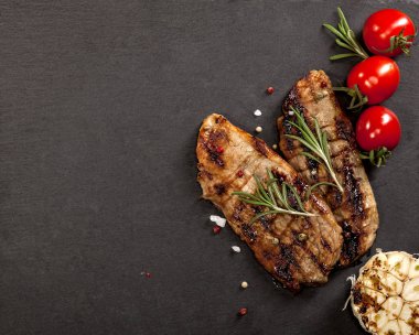 Siyah arka plan üzerine baharat ile ızgara sığır eti biftek