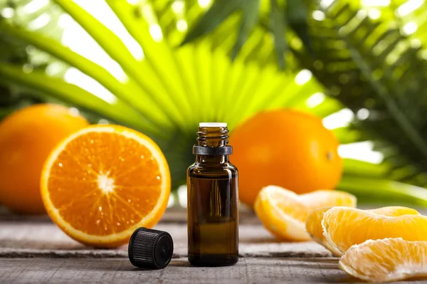 Óleo essencial de laranja sobre folhas verdes fundo — Fotografia de Stock