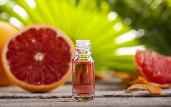 Grapefruit ätherisches Öl auf grünen Blättern Hintergrund — Stockfoto