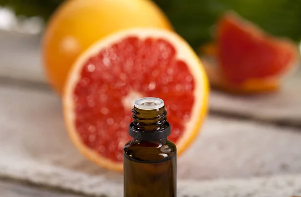 Grapefruit ätherisches Öl auf grünen Blättern Hintergrund — Stockfoto