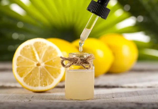 Citron eterisk olja på gröna löv bakgrund — Stockfoto