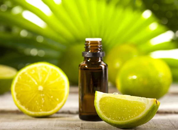 Óleo essencial de limão sobre folhas verdes fundo — Fotografia de Stock