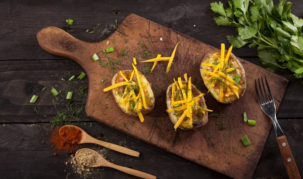 Gebakken gevulde aardappelen met spek, kaas, bieslook, dille en specerijen — Stockfoto