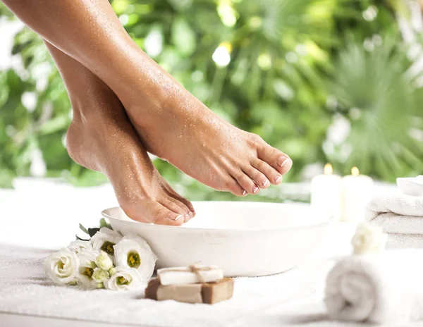 Foot spa on a tropical green leaves background