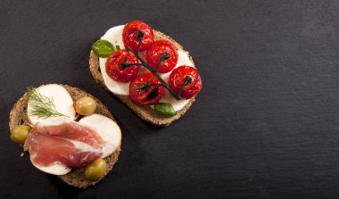 Bruschettas krem peynir, kiraz domates, fesleğen, füme peynir, salam, zeytin ahşap tablo