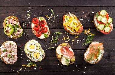 Koyu ahşap masa üzerinde farklı bruschettas kümesi. En iyi görünüm ve kopya alanı.