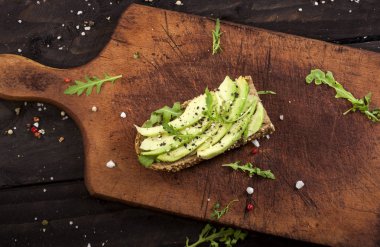 Bruschetta avokado, rucola susam ve tohumlar üzerinde ahşap masa