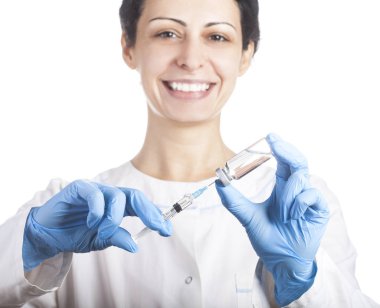 Bir şırınga ve iğne çözümünü bir şişeyle tutan doktor