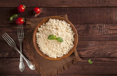 Ahşap arka planda bir kase pişmiş beyaz pirinç.