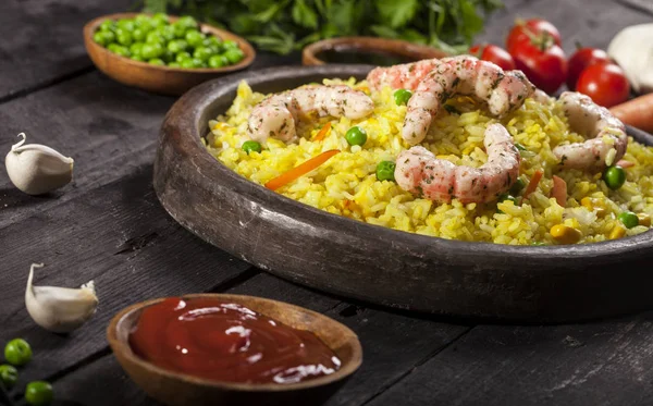 Gekochter Reis mit Garnelen, Curry und Gemüse in einem Gericht auf schwarzem Bambus-Hintergrund. — Stockfoto