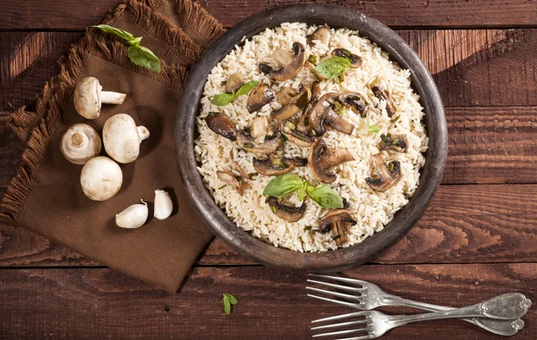 Gekookte witte rijst met mushroomsin een kom op houten achtergrond. — Stockfoto