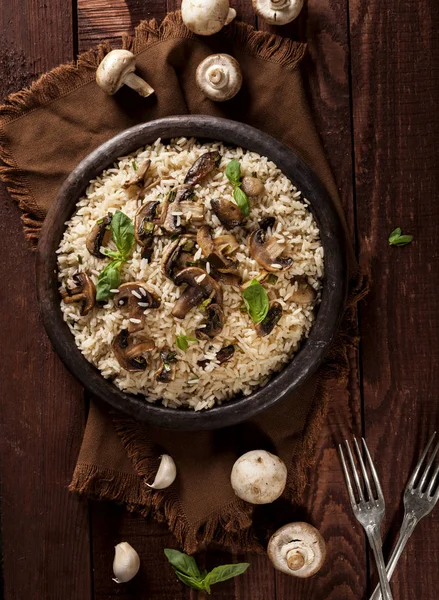 Cooked white rice with mushroomsin a bowl on wooden background.